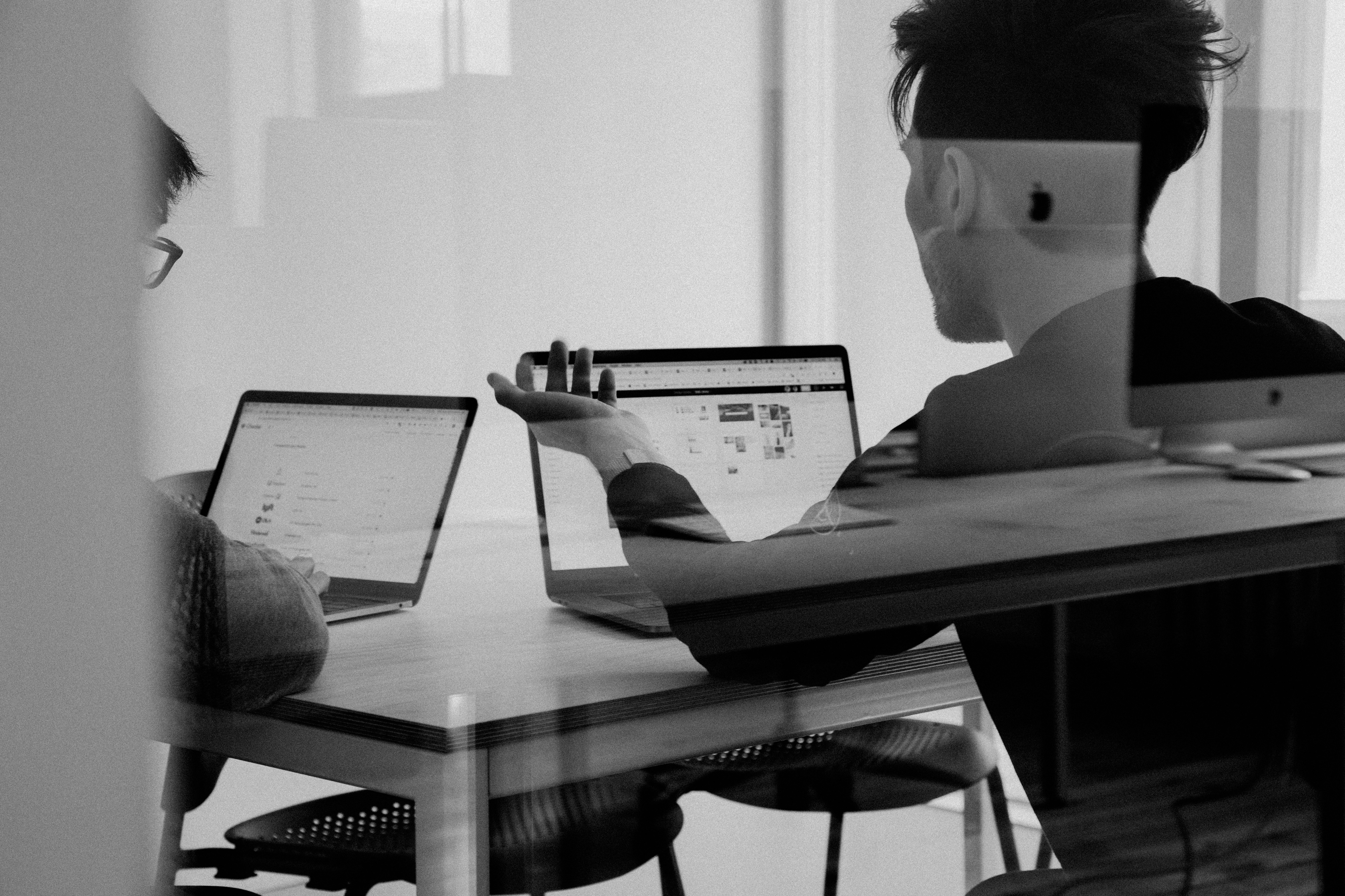 Engineering consultants collaborating around laptops
